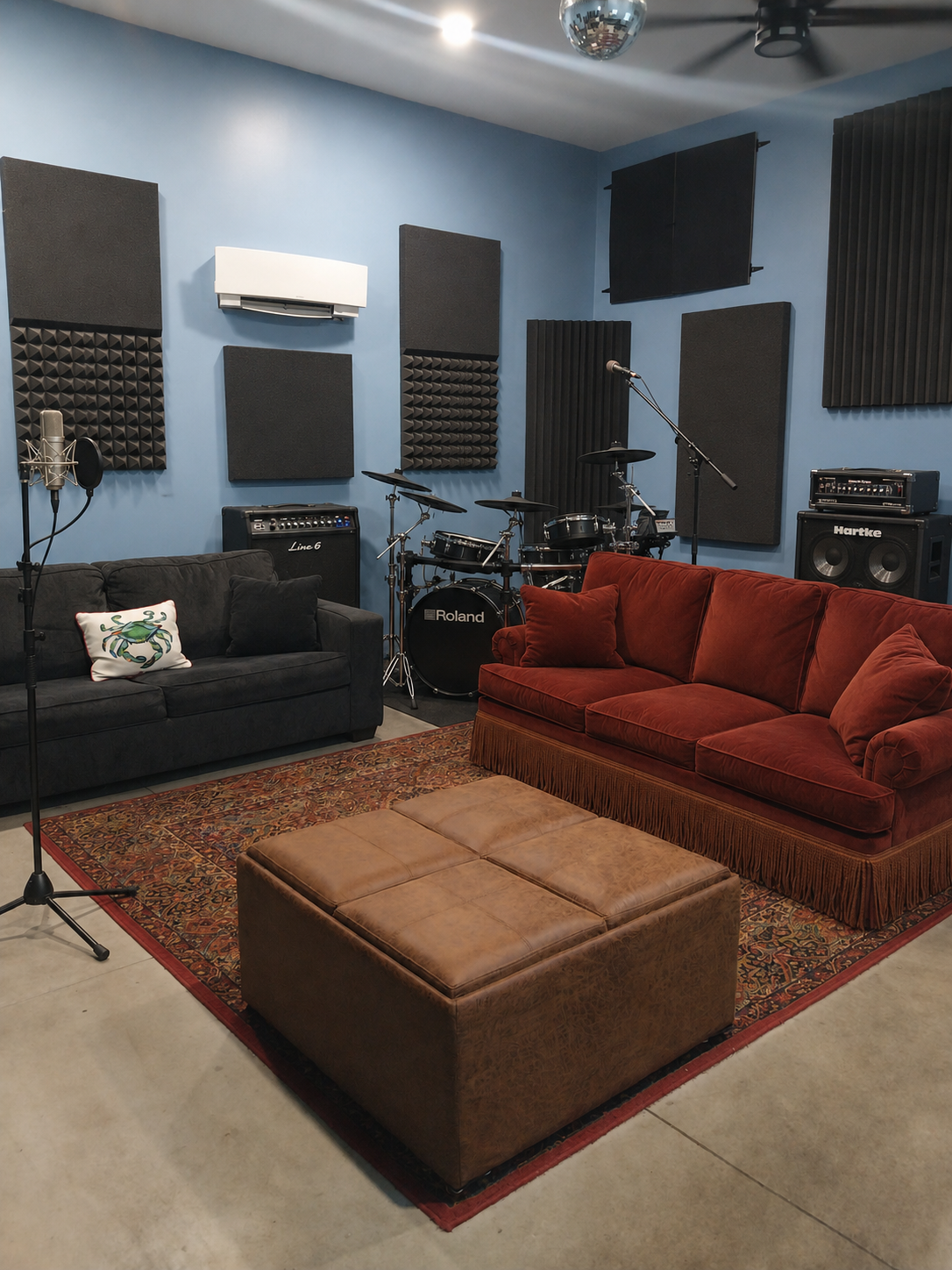The 214 lounge with a red velvet couch, drum kit, and warm rugs